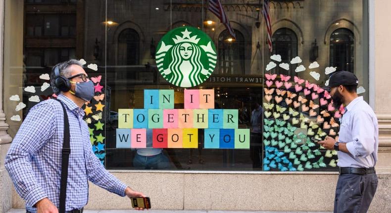 People walk outside Starbucks in midtown as New York City moves into Phase 3.