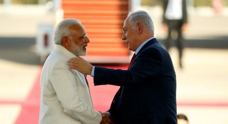 Israeli Prime Minister Benjamin Netanyahu (R) greets his Indian counterpart Narendra Modi (L) at Ben Gurion airport near Tel Aviv on July 4, 2017