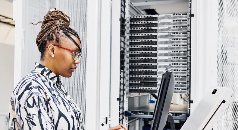 IT professional configures server in data center.