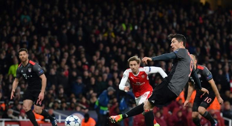 Bayern Munich's forward Robert Lewandowski (R) scores from a penalty during the UEFA Champions League last 16 second leg football match between Arsenal and Bayern Munich at The Emirates Stadium in London on March 7, 2017