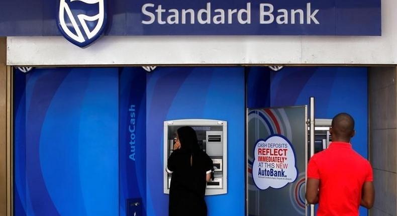 Customers queue to draw money from an ATM outside a branch of South Africa's Standard Bank in Cape Town, March 15, 2016. REUTERS/Mike Hutchings