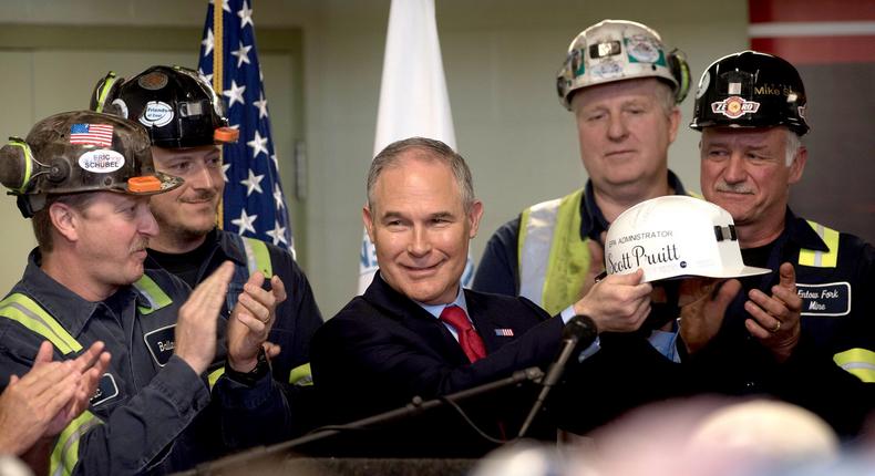 EPA administrator Scott Pruitt holds up a miner's helmet that he was given after speaking with coal miners at the Harvey Mine on April 13, 2017. On the back, the hat reads Make America Great Again.