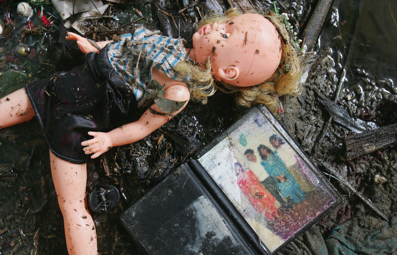 Rodzinne zdjęcie i zabawka w błocie pokrywającym teren po przejściu tsunami na Sri Lance