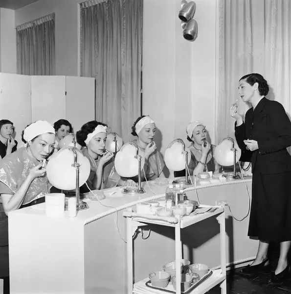 Około 1945 roku: urodzona w Polsce Helena Rubinstein (1870 - 1965) prowadzi w telewizji lekcje makijażu z grupą kobiet siedzących przed lustrami. (Zdjęcie: Hulton Archive / Getty Images)