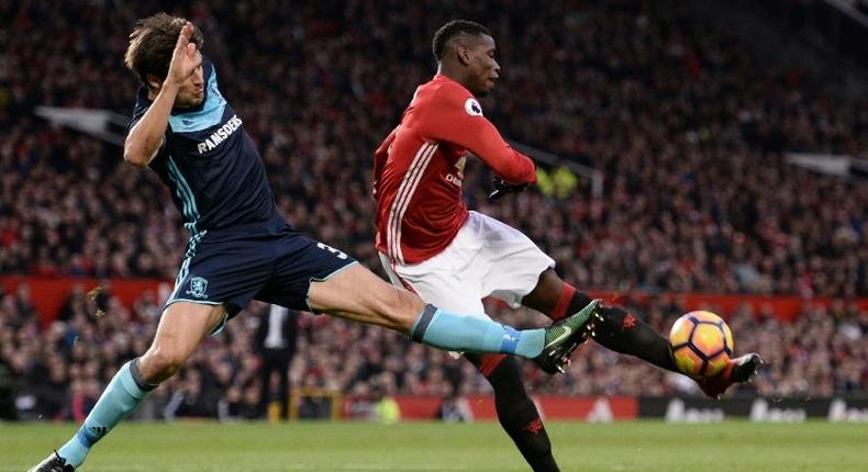 Manchester United's midfielder Paul Pogba (R) attemps to shoot past Middlesbrough's defender George Friend during the English Premier League football match at Old Trafford in Manchester, north west England, on December 31, 2016