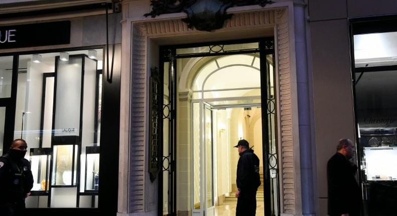 French police officers stand guard in front of the entrance of the building where the offices of Swiss watchmaker Girard Perregaux are located on rue de la Paix, in central Paris, following a robbery on October 20, 2016