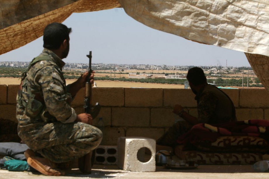Fighters of the Syrian Democratic Forces sit in a lookout position in the western rural area of Manbij.