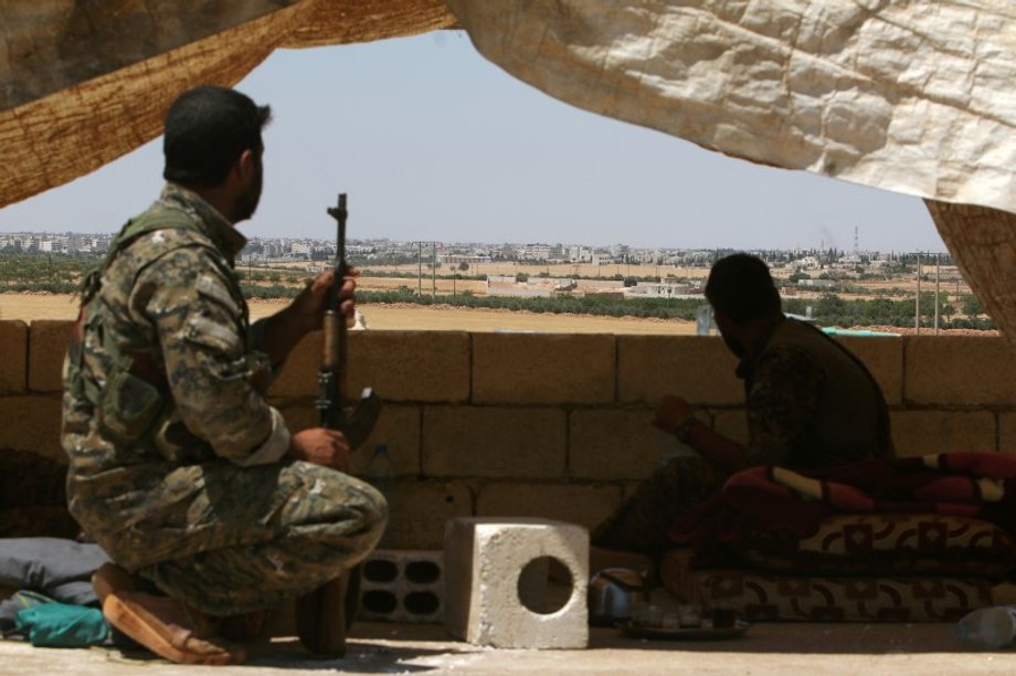 Fighters of the Syrian Democratic Forces sit in a lookout position in the western rural area of Manbij.