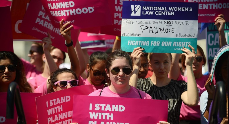 Protesters hold posters in support of Planned Parenthood at a rally to oppose the repeal of the Affordable Care Act and its replacement at Capitol Hill on June 21, 2017.