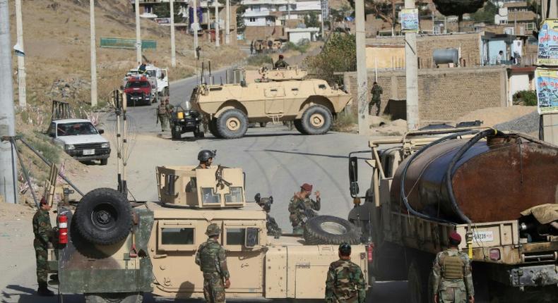 Afghan National Army soldiers stand guard and inspect the site of a suicide car bomb attack by the Taliban in Char Asiab district, south of Kabul, on September 12