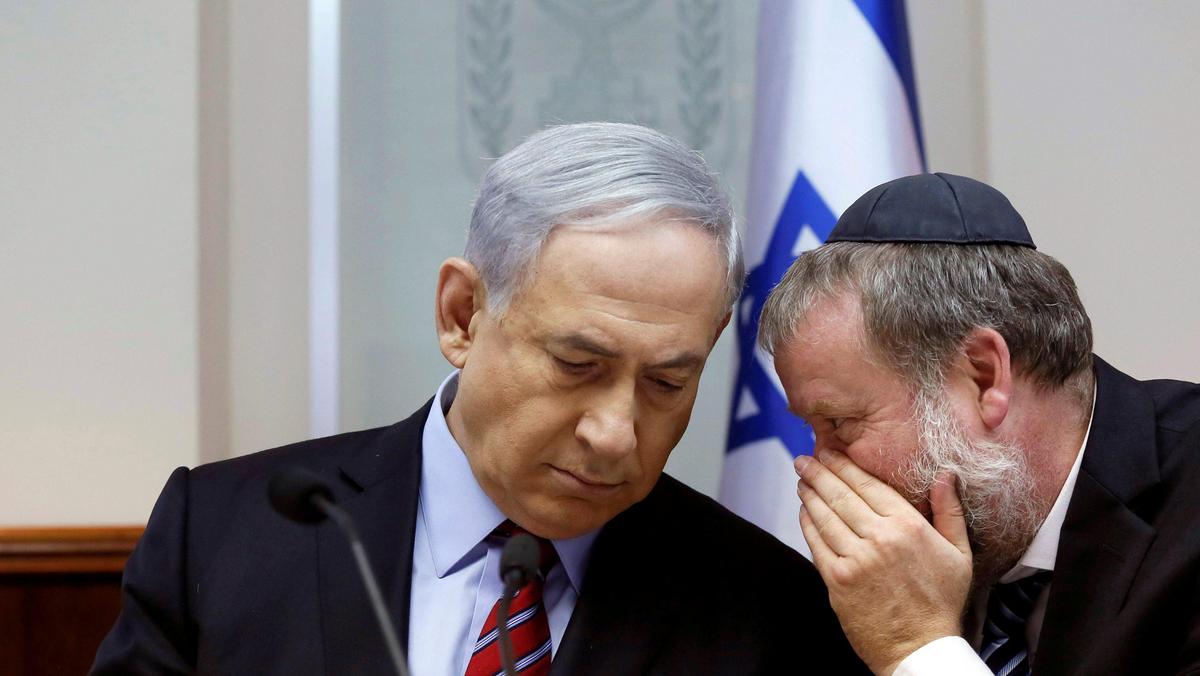 FILE PHOTO: Israel's Prime Minister Netanyahu listens to Cabinet Secretary in Jerusalem