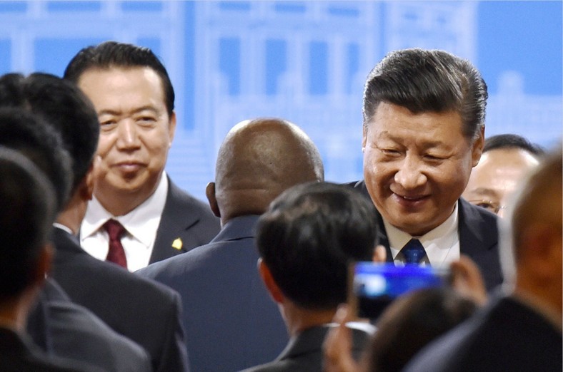 Prezydent Interpolu Meng Hongwei (po lewej, z tyłu) wraz z przewodniczącym Xi Jinpingiem (po prawej) biorą udział w dorocznym spotkaniu Interpolu w Pekinie, Chiny, wrzesień 2017 r.