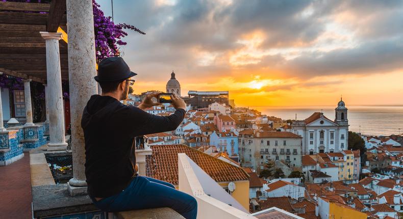 A tourist photographs the sunrise in Lisbon, Portugal, ranked as the top city in the world for remote workers.Marco Bottigelli/Getty Images