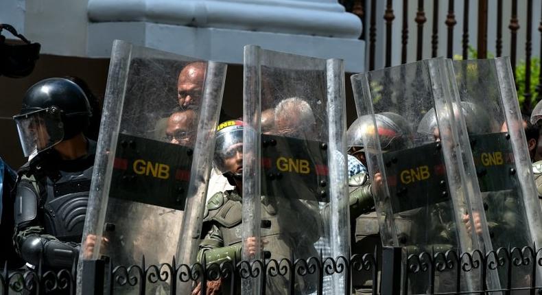 National Guard members protect opposition lawmakers under attack by supporters of President Nicolas Maduro's government while trying to enter to the National Assembly