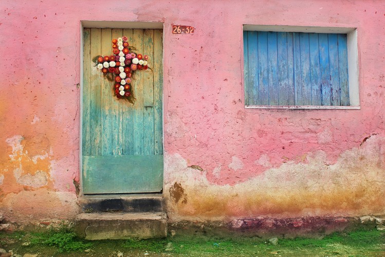 Kwiatowa dekoracja w kształcie krzyża na jednym z domów w biednej dzielnicy