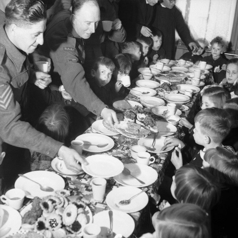 Brytyjscy żołnierze organizują mikołajkową kolację dla dzieci. Fot. Midgley (Sgt), No 5 Army Film & Photographic Unit