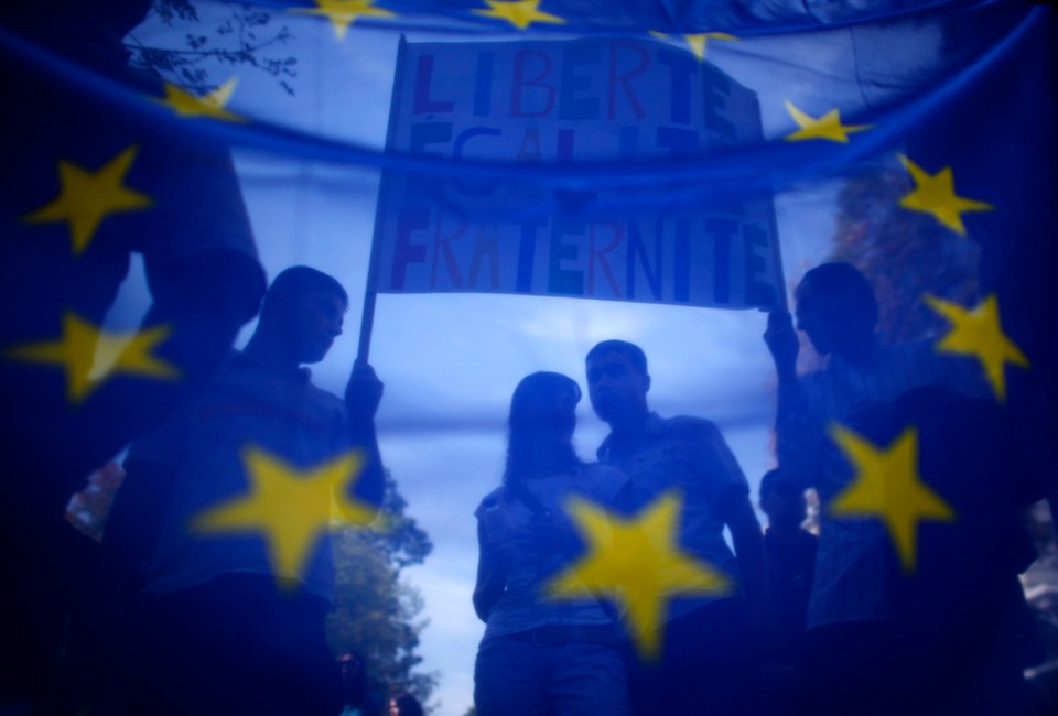 Supporters and members of Bulgaria's Roma community are seen through European Union flag during a protest in front of the French embassy in Sofia