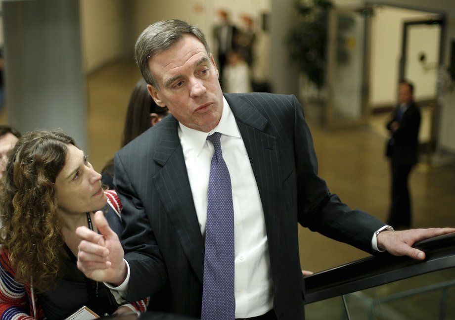 Senator Warner talks to reporters as he exits a Washington D.C. metro stop.