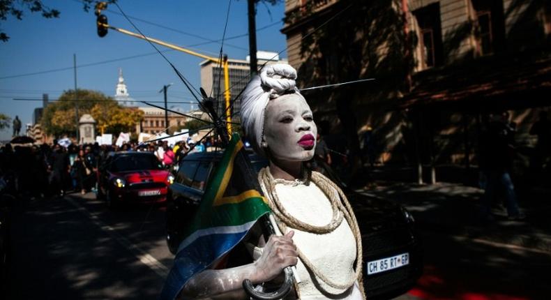 A woman dressed in a wedding gown and holding a South African flag leads a march in Pretoria against the abuse of women following the spike in reports of women being murdered and raped in various parts of the country