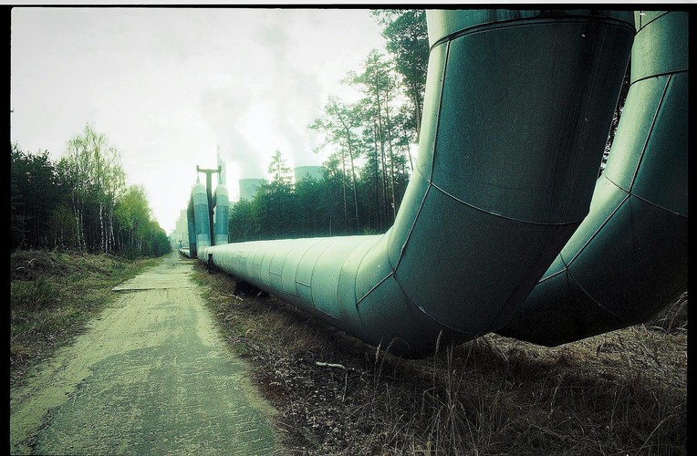 Jednak skażenie powietrza to tylko część problemu. Zanieczyszczeniu ulega również woda. Jedną z 'ofiar' elektrowni jest rzeka Widawka. Przepływa przez tereny odkrywkowej Kopalni Węgla Brunatnego Bełchatów, więc woda w rzece częściowo pochodzi z pomp głębinowych odwadniających odkrywkę Bełchatów. Brzeg rzeki został uregulowany - czytaj wybetonowany. Podniosła się również temperatura wody i przyspieszył nurt. W rezultacie wiele gatunków kręgowców zostało przetrzebionych lub zniknęło z Widawki.

Na zdjęciu: Fragment rurociągu prowadzącego do zalewu Słok, doprowadzający wodę do chłodzenia.