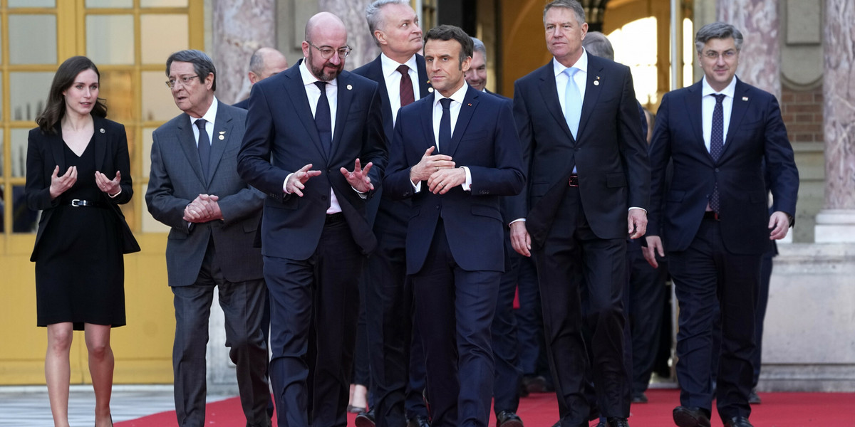 Liderzy państw unijnych wchodzący na salę obrad szczytu europejskiego w Wersalu