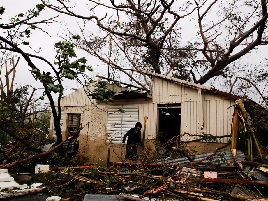 A man looks for valuables in the damaged house of a relative after the area was hit by Hurricane Maria in Guayama, Puerto Rico September 20, 2017.