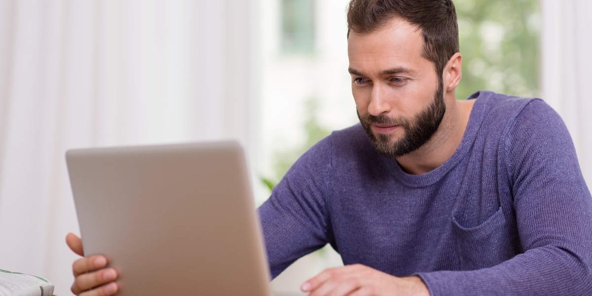 Man working on his laptop computer at home