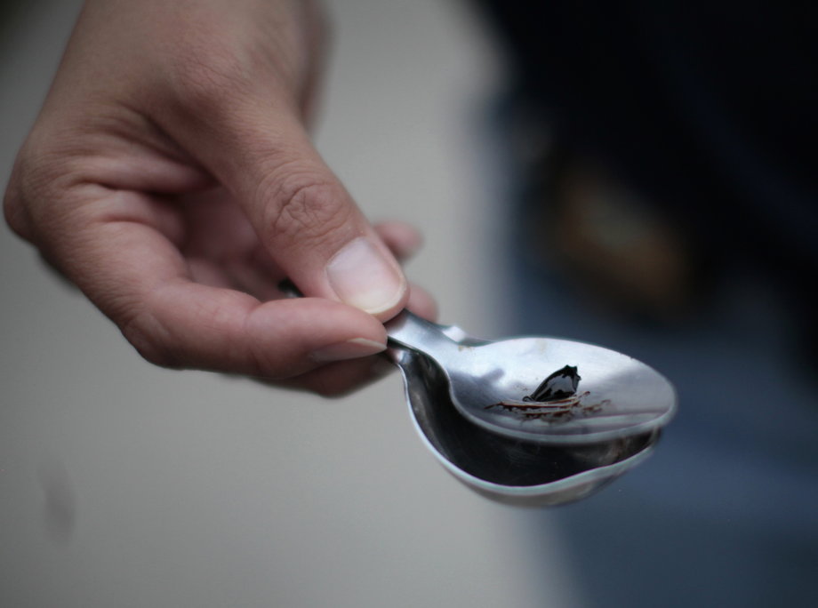 Orange County Deputy Probation Officer Erin Merritt holds a spoon with black-tar heroin, which she found in a probationer's apartment in Santa Ana, California, July 22, 2011.