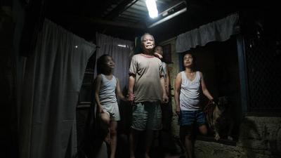 Filipiny. Simplicio Mondas, jego córka Olivia i wnuczka Maristela po zamontowaniu świecącej butelki 