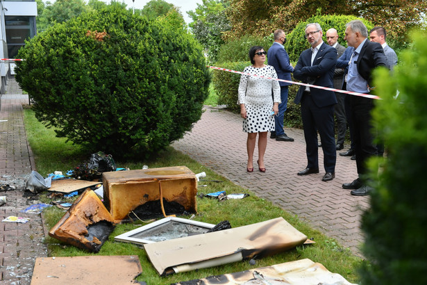 Minister zdrowia Adam Niedzielski (4P) oraz dyrektor PSSE Zamość, Państwowy Powiatowy Inspektor Sanitarny w Zamościu Stanisław Jaślikowski (2P) przy podpalonym budynku Powiatowej Stacji Sanitarno-Epidemiologicznej przy ulicy Peowiaków w Zamościu