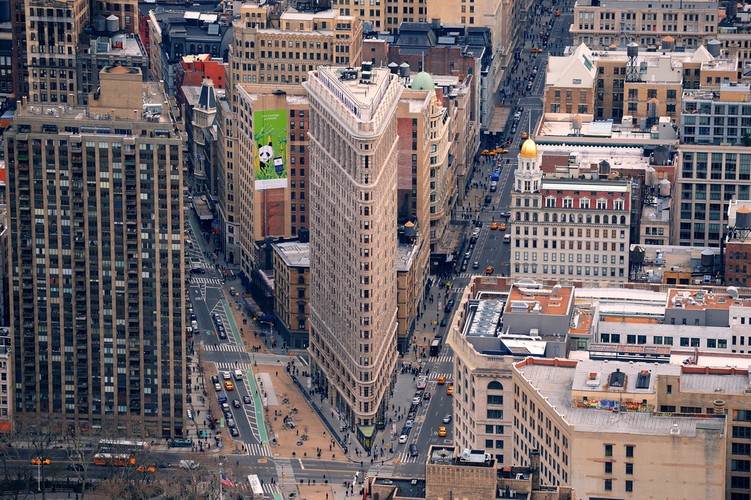 Flatiron w Nowym Jorku. Wysokość: 87 metrów, 22 piętra. Stojący przy piątej Alei na Manhattanie budynek to kolejna ikona nowojorskiego krajobrazu i perła w historii architektury, przyciągająca uwagę wielu artystów. Choć na dzisiejsze czasy jego rozmiar nie robi wrażenia, kiedy powstał w roku 1902 zachwycał nowoczesnymi rozwiązaniami technologicznymi. Obecnie znajdujące się w nim biura zajmują wydawnictwa zebrane w grupie Macmillan.