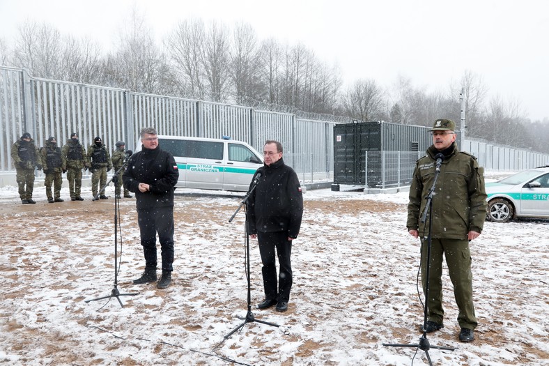 Zakończenie budowy płotu na granicy. Na zdjęciu szef MSWiA Mariusz Kamiński (C), jego zastępca Maciej Wąsik (L) oraz komendant Straży Granicznej gen. dyw. Tomasz Praga (P)