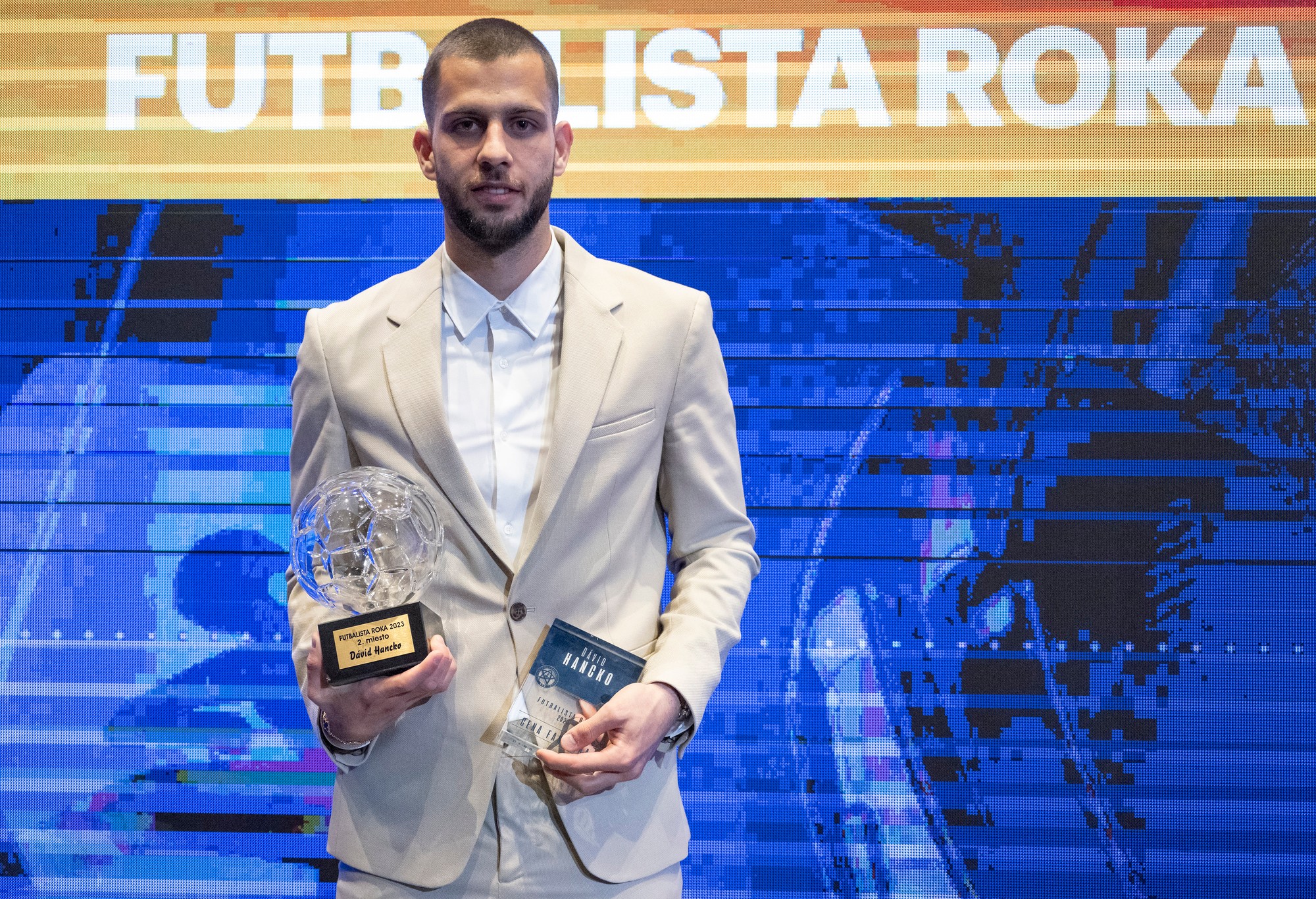 Dávid Hancko pózuje s dvoma cenami na vyhlásení výsledkov galavečera Futbalista roka 2023.