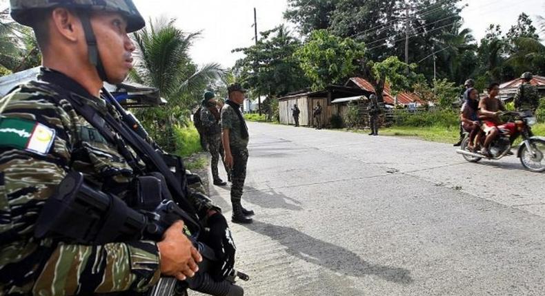 Members of Muslim rebel group Moro Islamic Liberation Front stand guard in the town of Sultan Kudarat ahead of the surrender of combatants with their firearms to President Benigno Aquino III