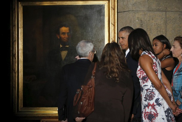 U.S. President Barack Obama views a portrait of former U.S. president Abraham Lincoln on a walking t