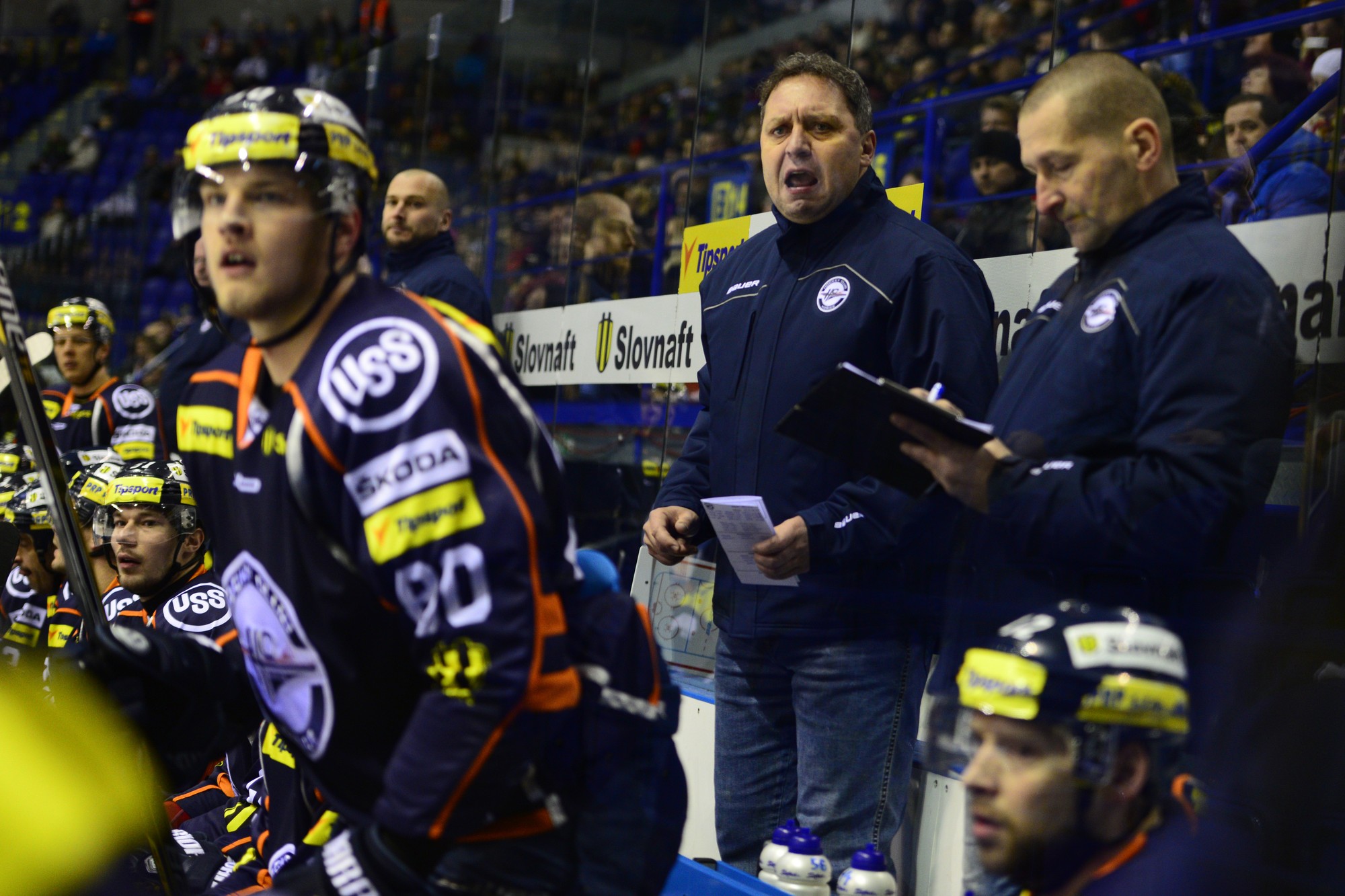Na snímke je striedačka HC Košice, hore uprostred stojí hlavný tréner mužstva Peter Oremus, vpravo vedúci klubu Marko Mily a vľavo asistent trénera Roman Šimíček v roku 2015.