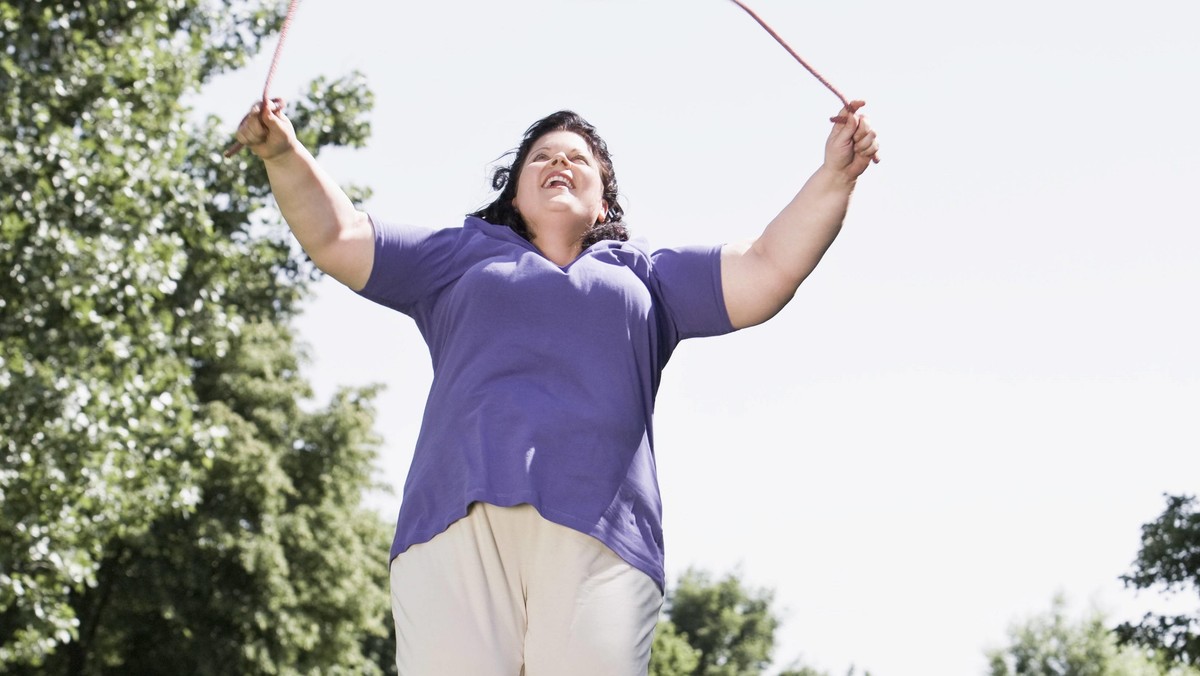 overweight woman skipping in park