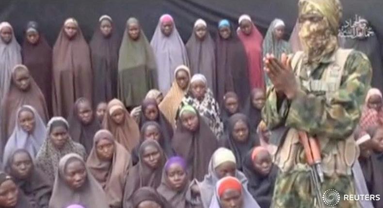 A still image from a video posted by Nigerian Islamist militant group Boko Haram on social media, seen by Reuters on August 14, 2016, shows a masked man talking to dozens of girls the group said are school girls kidnapped in the town of Chibok in 2014.  Social Media