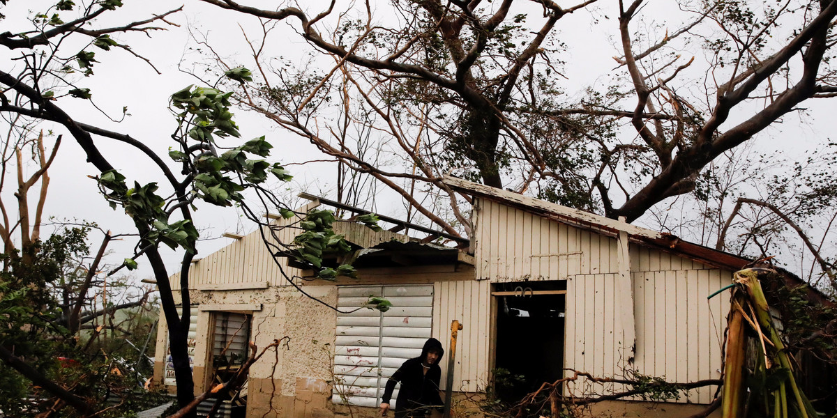 A man looks for valuables in the damaged house of a relative after the area was hit by Hurricane Maria in Guayama, Puerto Rico September 20, 2017.