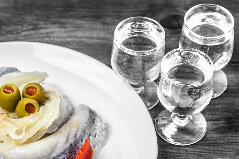 Marinated herring and vodka shot. Traditional polish appetizer.