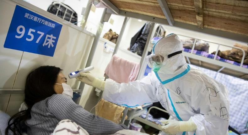 A health worker checks the temperature of a patient at a hospital in Wuhan