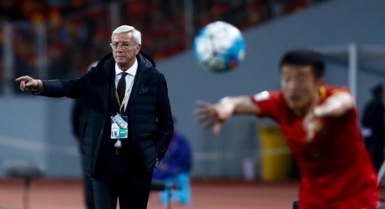 China's coach Marcello Lippi (L) watches from the sideline as Jiang Zhipeng throws in the ball during their 2018 FIFA World Cup qualifying match against Qatar, in Kunming, in November 2016