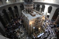 Christian worshippers surround the Edicule as they take part in a Sunday Easter mass procession in t