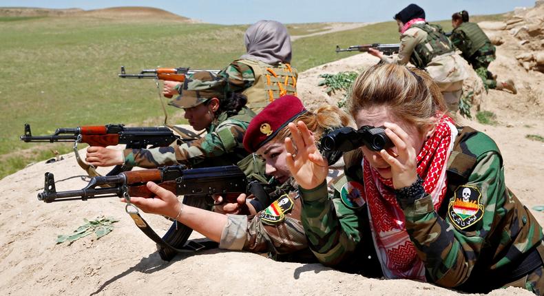 An Iraqi Kurdish female fighter and a Yazidi female fighter aim their weapons near the front line of the fight against ISIS near Mosul, Iraq, April 20, 2016.