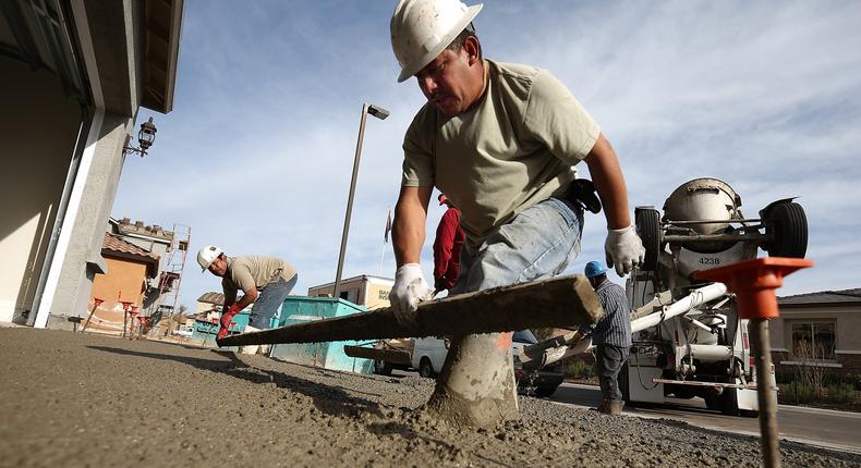 Workers pour concrete for a driveway of a new home at the Pulte Homes Fireside at Norterra-Skyline housing development on March 5, 2013 in Phoenix, Arizona.