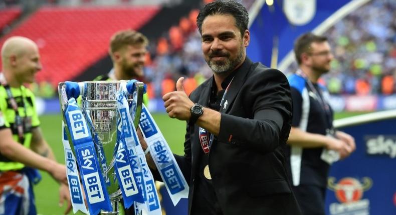 Huddersfield Town's head coach David Wagner gestures as he holds the Championship Playoff trophy on the pitch after winning the penalty shoot-out in the English Championship play-off final football match against and Reading