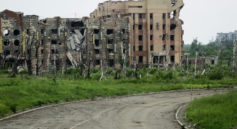 An armed pro-Russian separatist of the self-proclaimed Donetsk People's Republic walks in front of the destroyed Donetsk International Airport on June 1, 2016