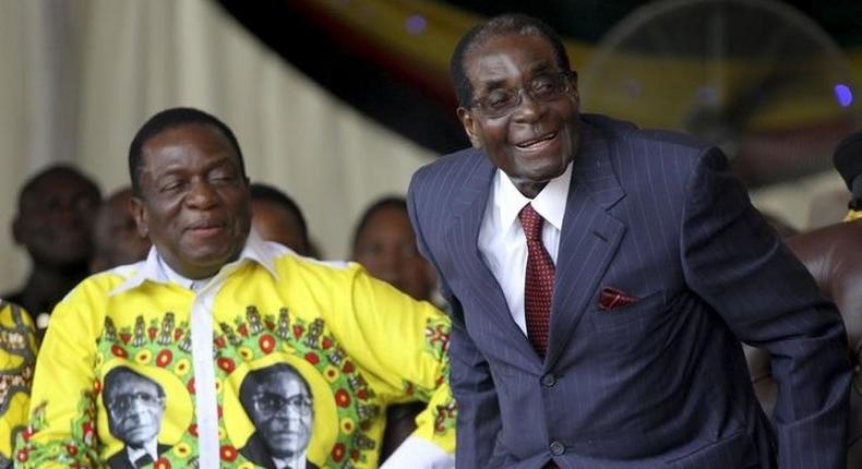 Zimbabwe's President Robert Mugabe (R) shares a joke with his vice-President Emmerson Mnangagwa during Mugabe's birthday celebrations at Great Zimbabwe in Masvingo, February 27, 2016. 