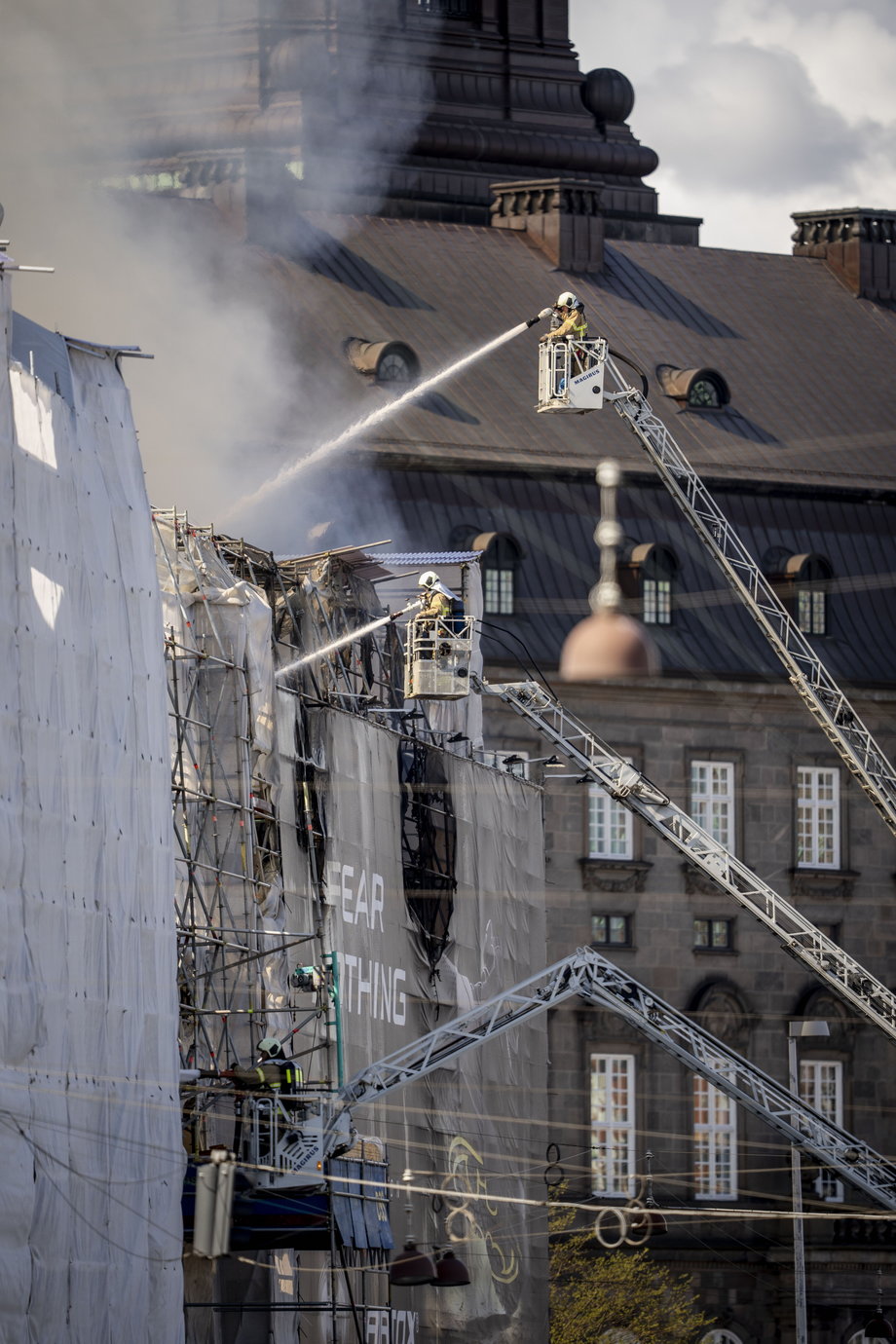 Strażacy gaszą pożar zabytkowego budynku Starej Giełdy Papierów Wartościowych w Kopenhadze. 16 kwietnia 2024 r.