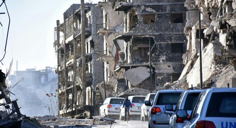 A UN convoy drives past damaged buildings in the eastern neighbourhoods of Syria's Aleppo on February 1, 2017